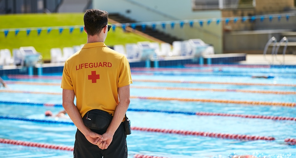 Lifeguard patrolling outdoor pool